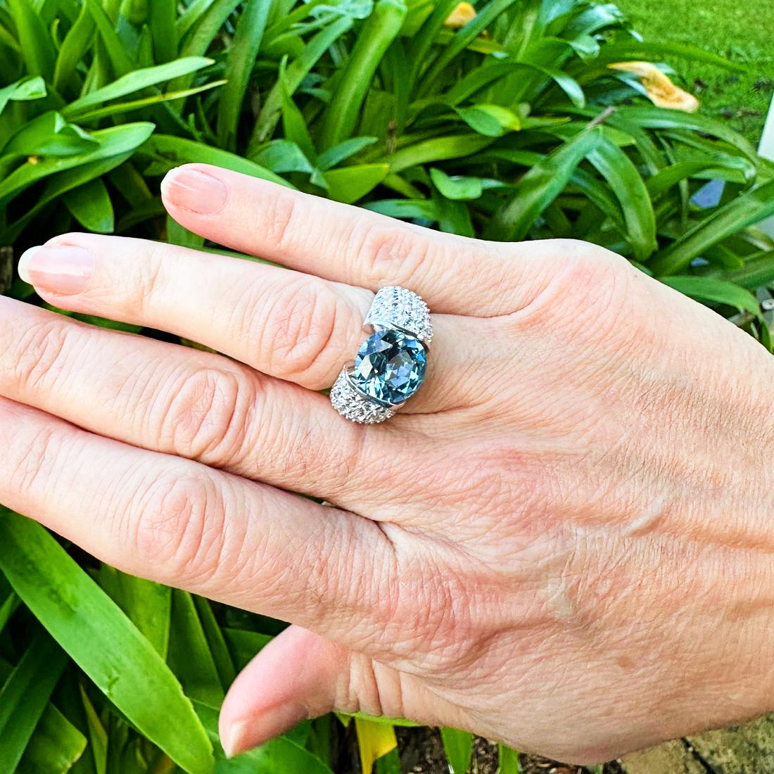 Deep Ocean Ring in 925 sterling silver features a generous 3-carat blue facet cut cubic zirconia stone surrounded by clear cubic zirconia stones. Worldwide shipping. Affordable luxury jewellery by Bellagio & Co.