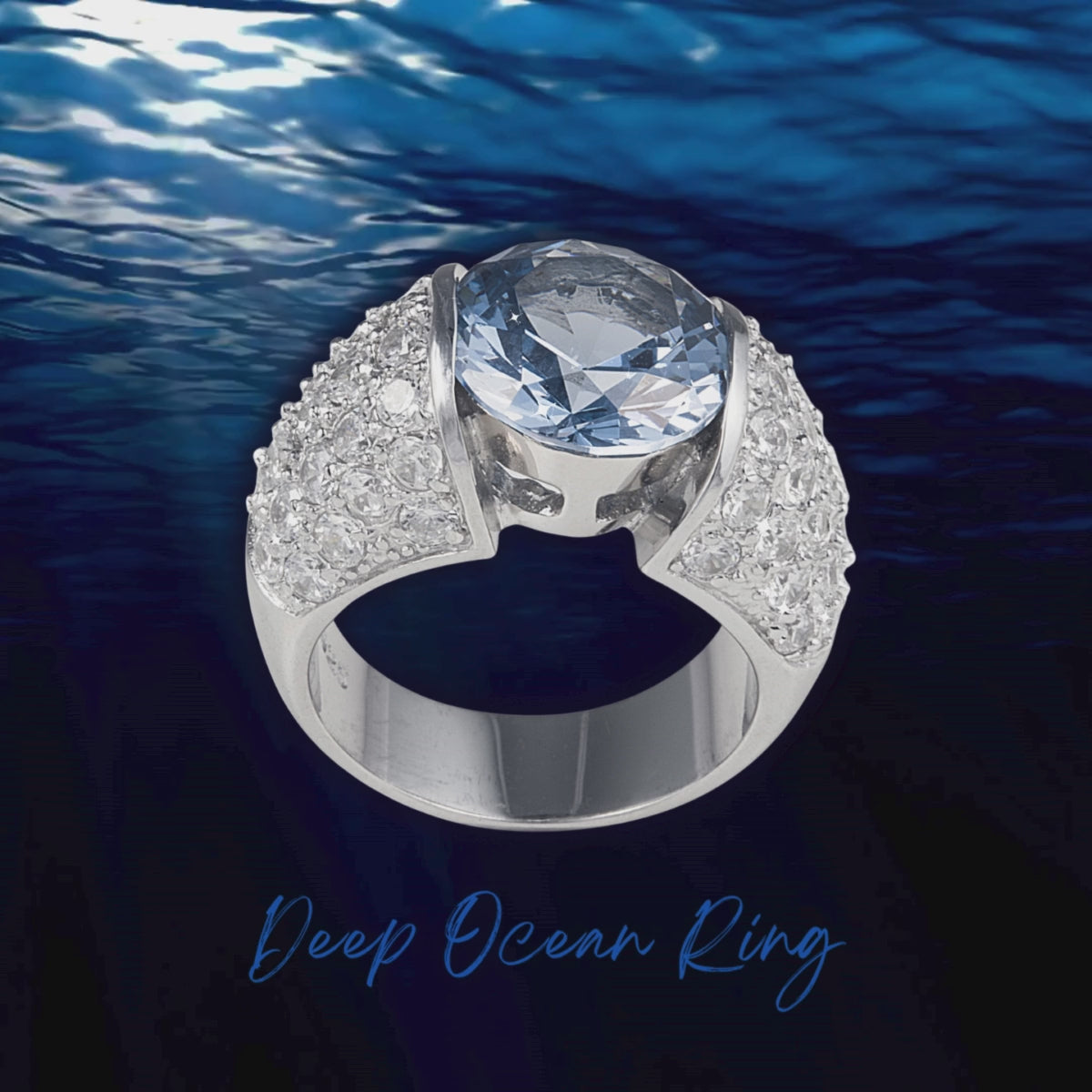 Deep Ocean Ring in 925 sterling silver features a generous 3-carat blue facet cut cubic zirconia stone surrounded by clear cubic zirconia stones. Worldwide shipping. Affordable luxury jewellery by Bellagio & Co.