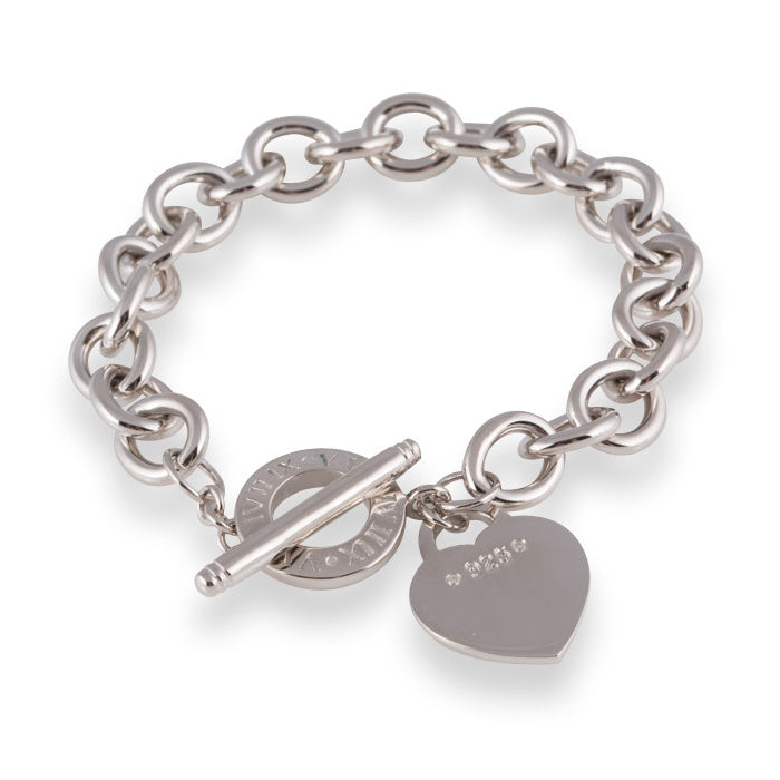 The Amor Bracelet is a solid belcher chain bracelet in 925 sterling silver with classic heart charm stamped with '925 Sterling Silver' and 2 cubic zirconia stones for subtle bling. Toggle Clasp. Worldwide shipping.